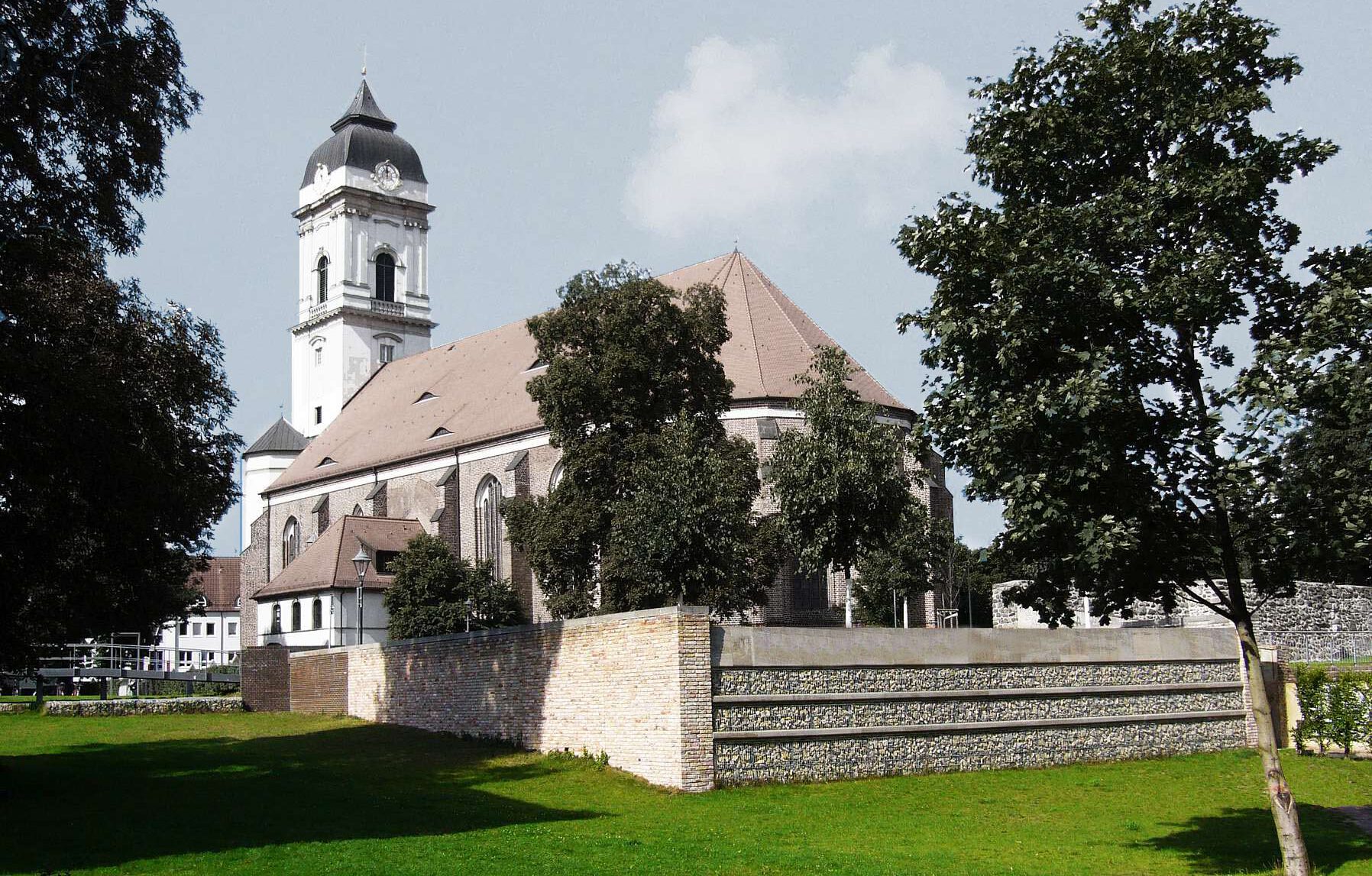 Denkmalgeschützte Kirche in Fürstenwalde mit Ummauerung, Bäumen und Wiese